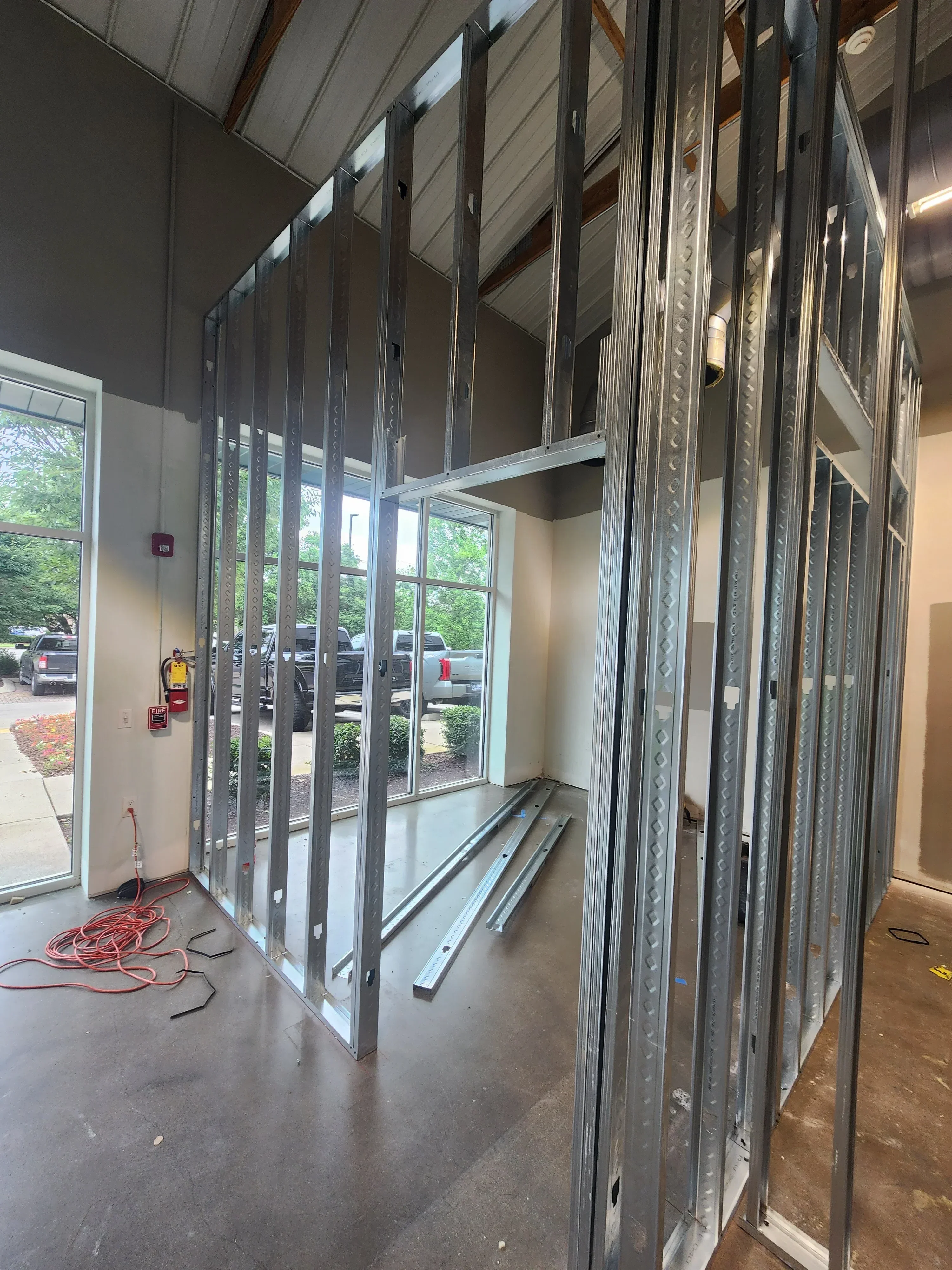 Aluminum garage door frame with diamond plate tracks and multi-panel windows during installation