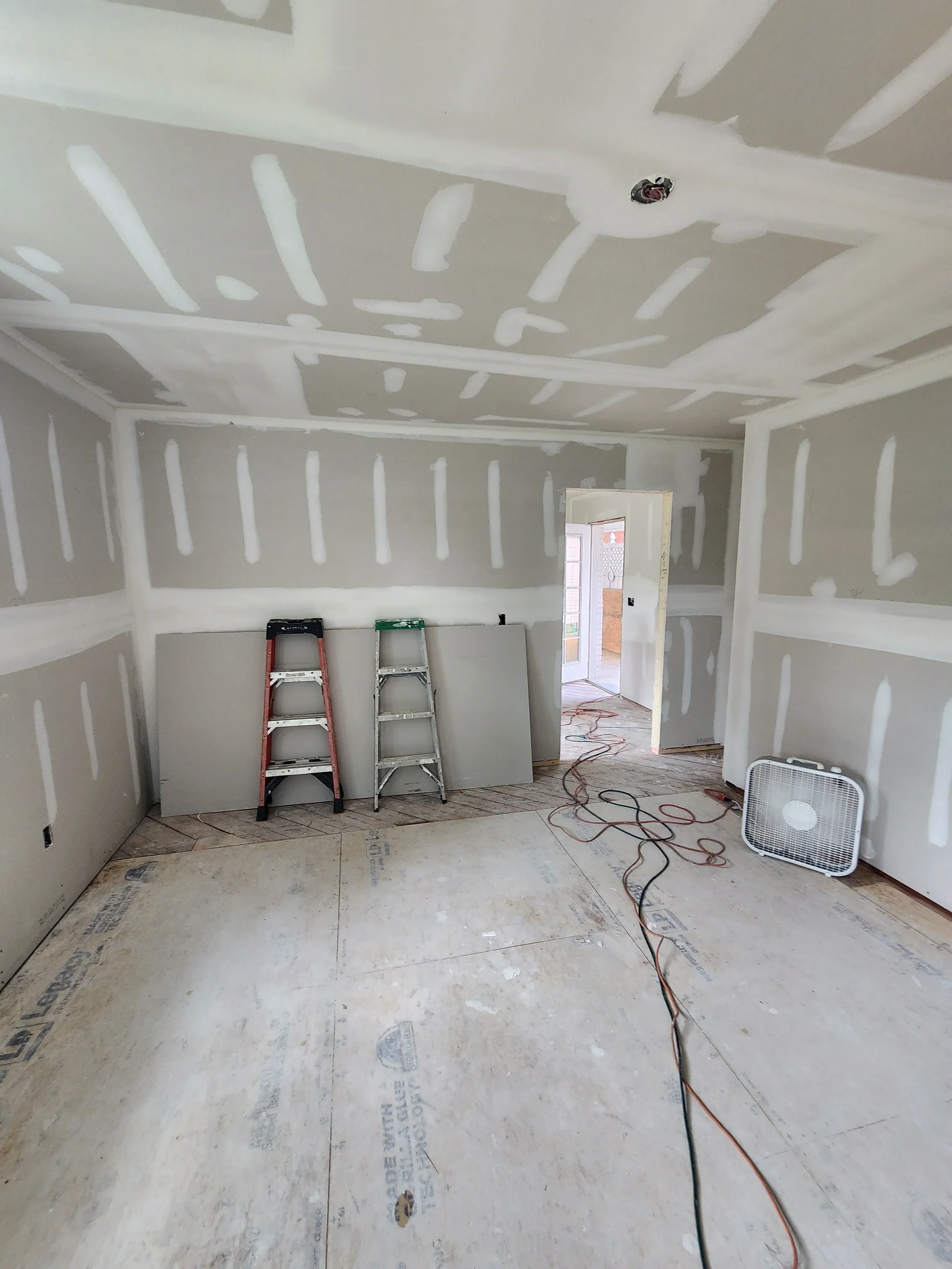 Kitchen interior with drywall installation, electrical wiring, and HVAC ductwork during construction phase