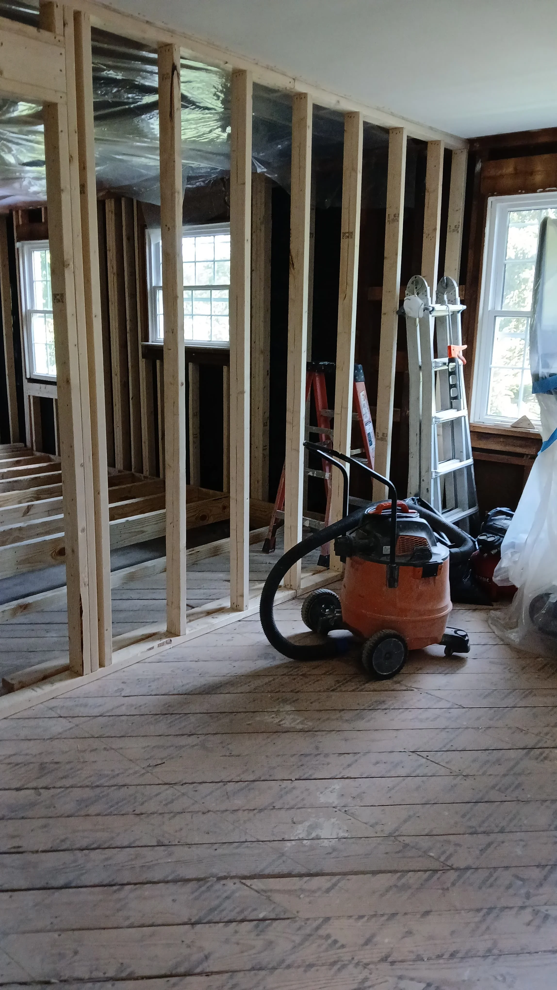 Kitchen framing with new stud walls, headers, and moisture barrier during renovation
