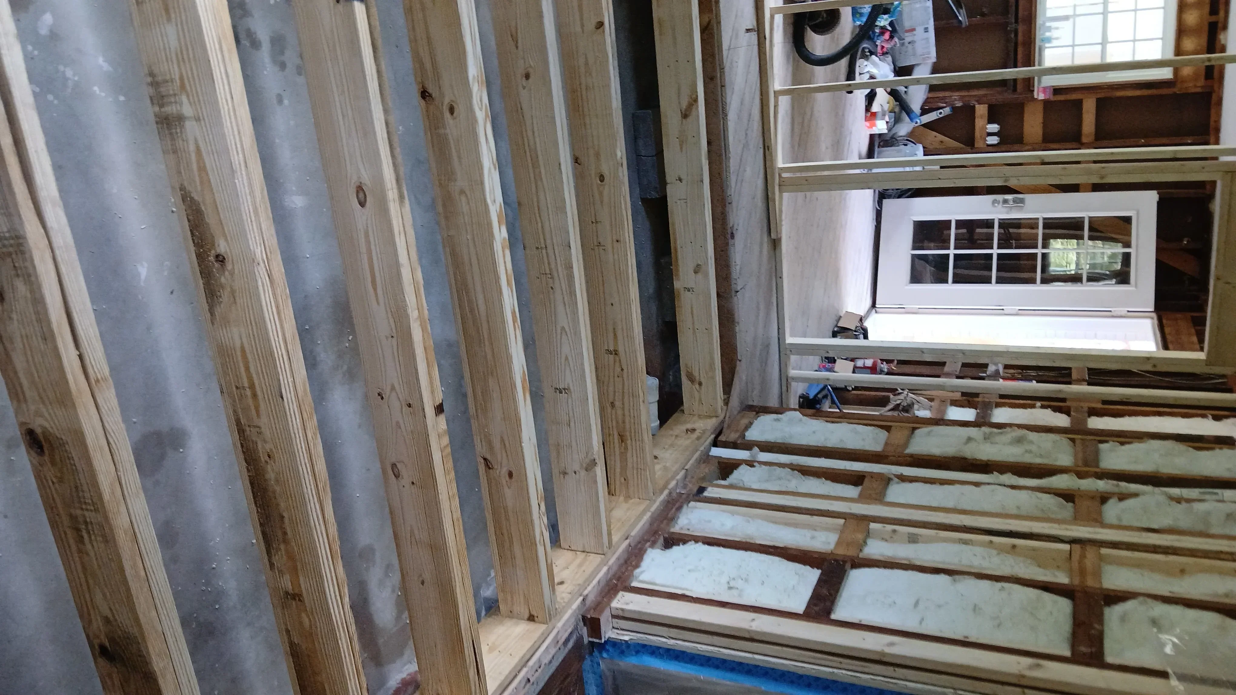 New floor framing with wooden joists and metal beams in kitchen renovation project