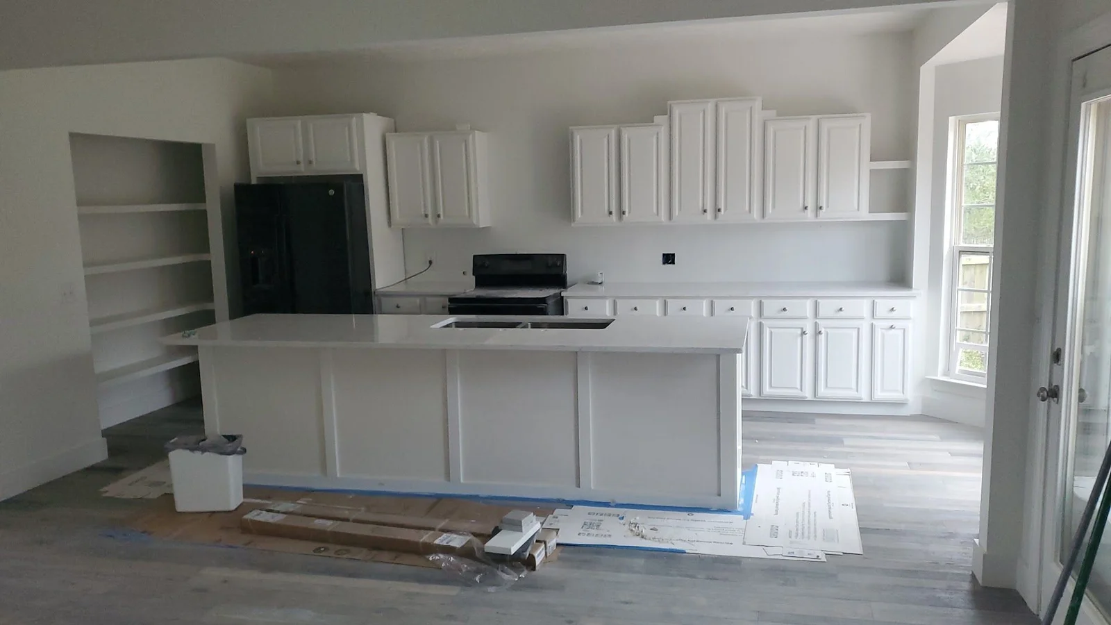 A newly installed kitchen island with a built-in cabinet base and countertop overhang in a Nashville home kitchen. The island sits centered in an open kitchen layout with clear walkways on both sides.